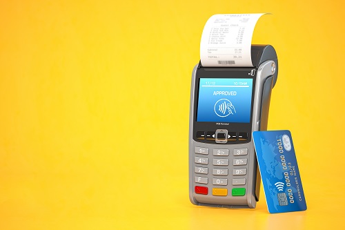 card reader, receipt and debit card on orange background